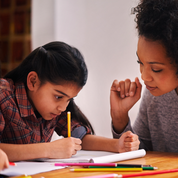 elementary student doing schoolwork with parent