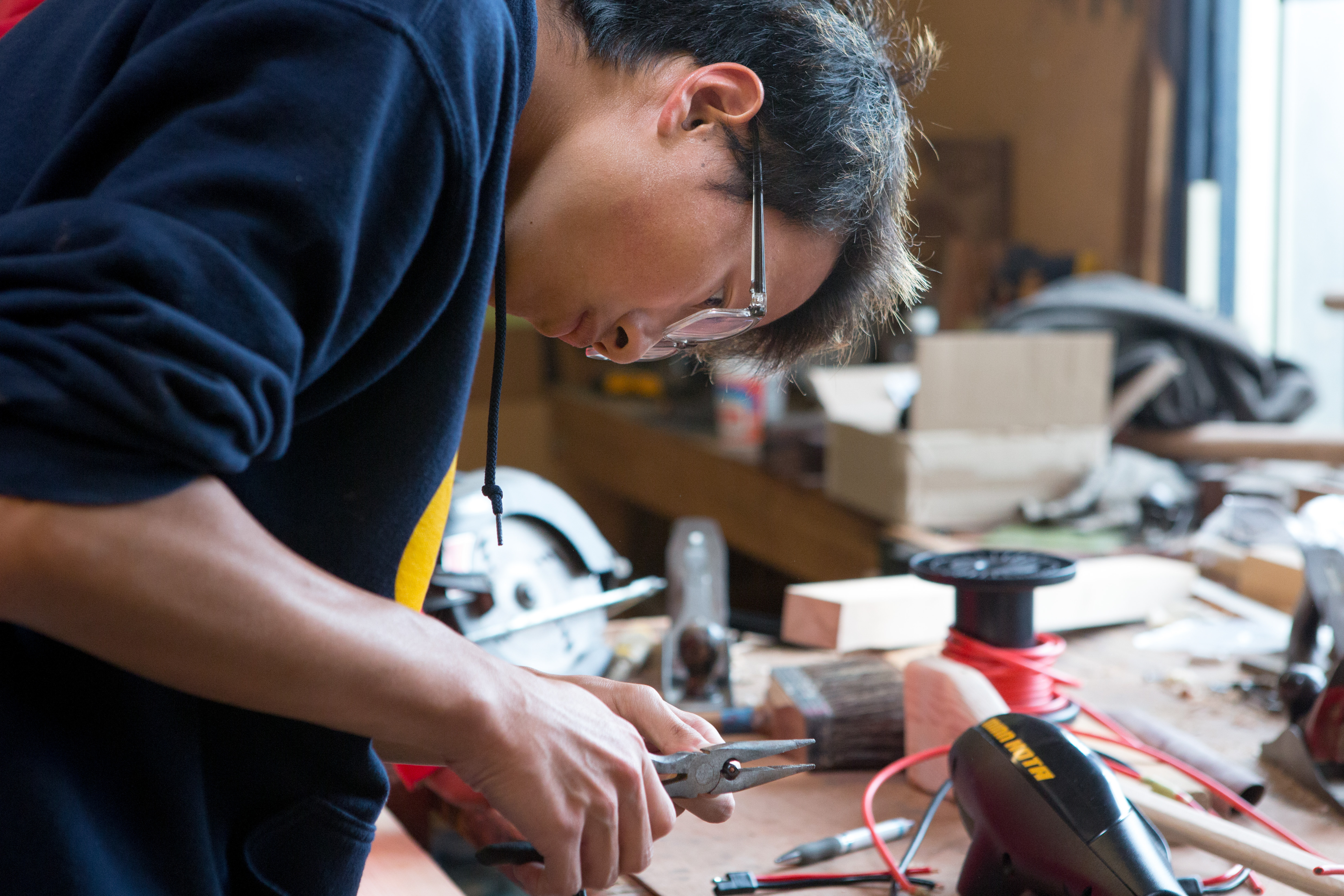 Boy working on boat project with pliers 