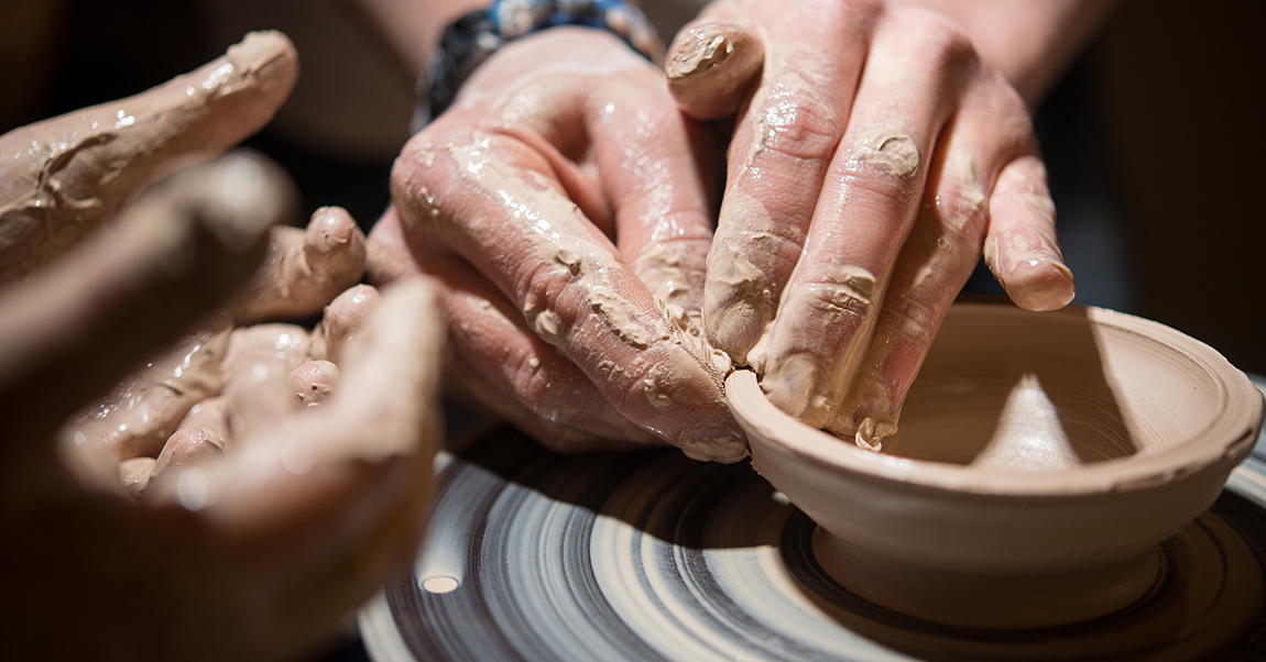 Students hands working with clay