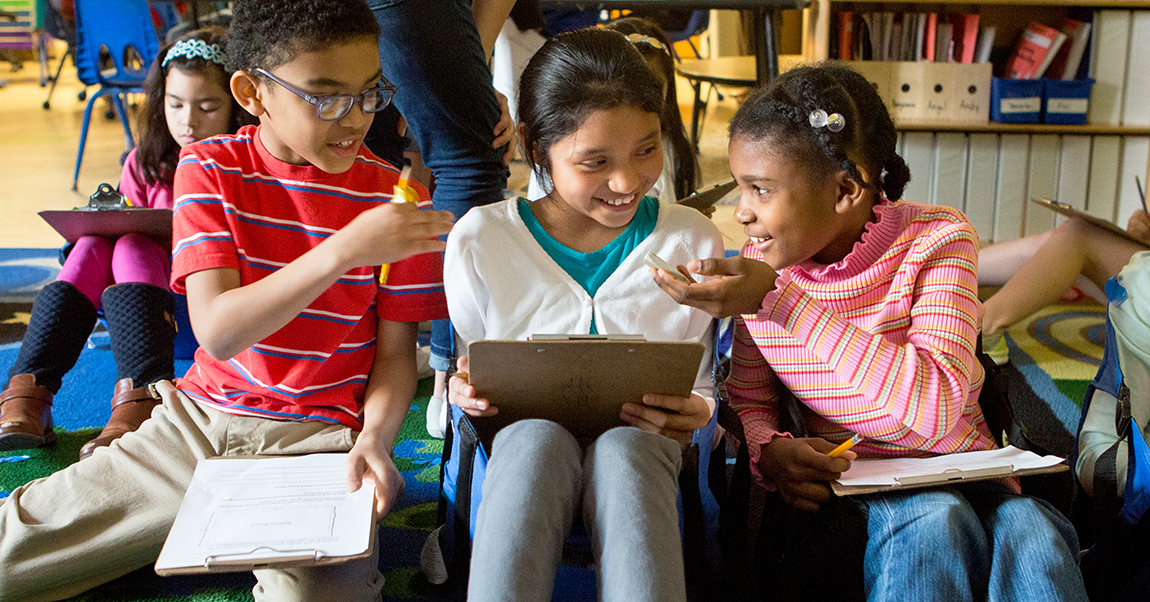 Three young students sharing ideas in class