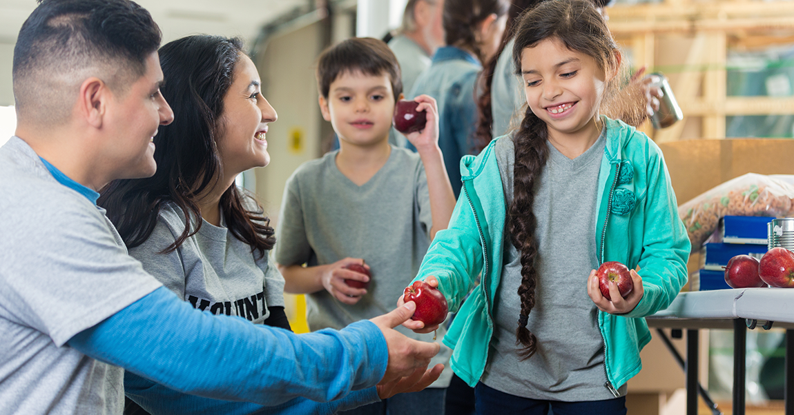 student handing out food at a food bank