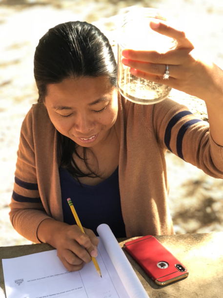 working on a PBL project by review the contents of a glass jar and her notes