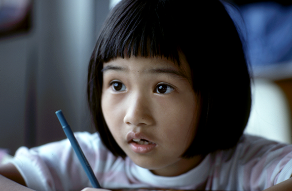 student with a pen and a questioning look on her face