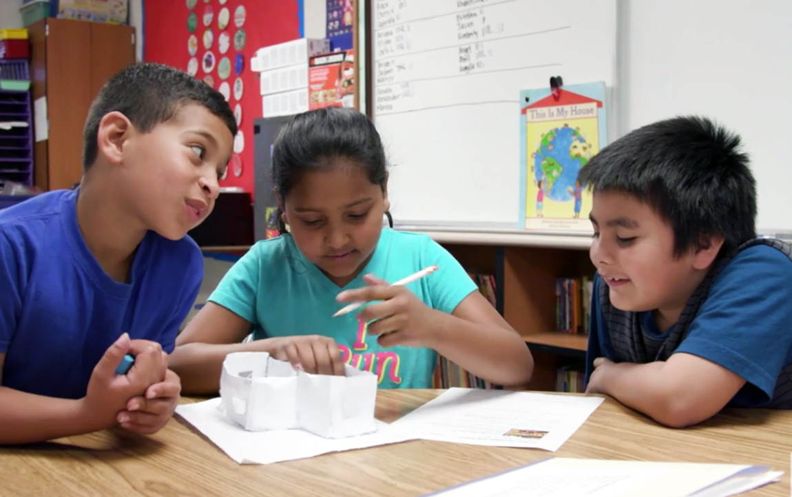 students at desk working together.