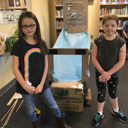 two girls standing front of their project 