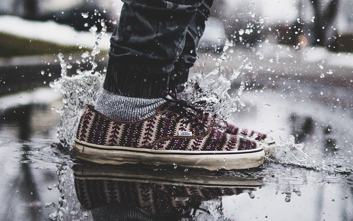 person jumping into a puddle (you can only see the shoes)