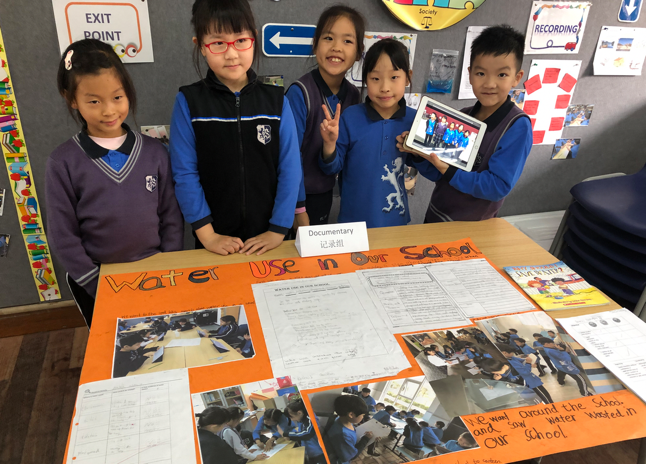 young students standing in front of a poster for "water used in our schools"