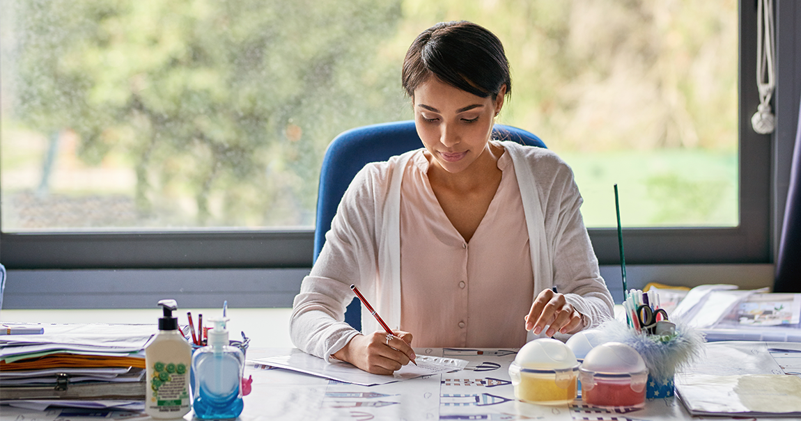 teacher sitting at desk with papers