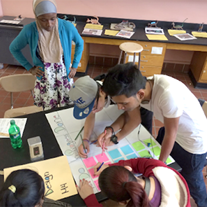 group of students at a table working on a kanban board