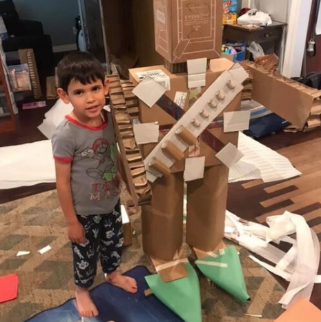 young student with handmade cardboard robot