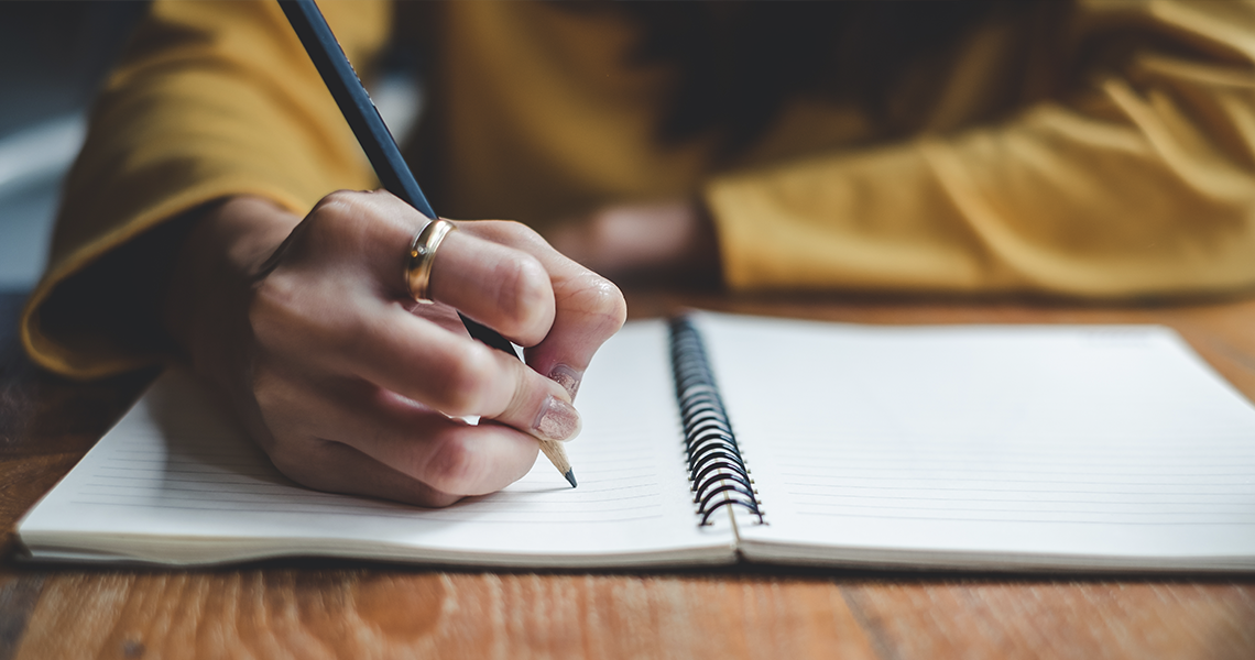 teacher writing in notebook