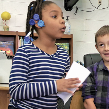 Young female student participating in class discussion