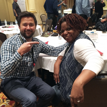 two faculty members smiling at a table