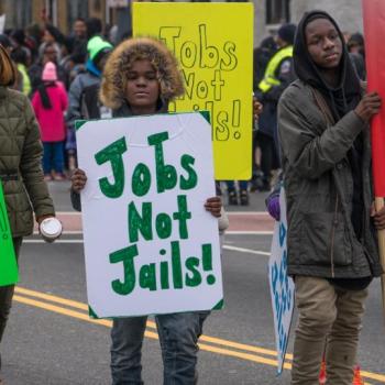 People in protest with signs, one reads 'jobs not jail'