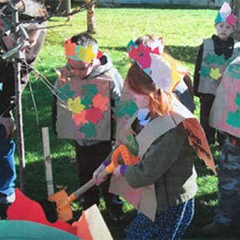 kids in paper armor and crowns outside doing a class project