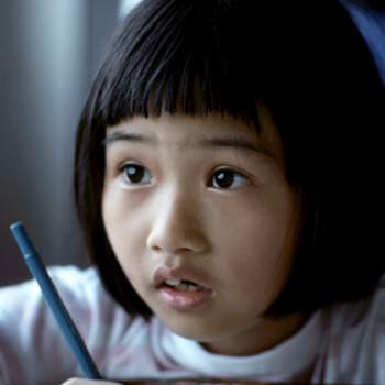 student with a pen and a questioning look on her face