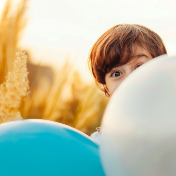 boy hiding behind balloons
