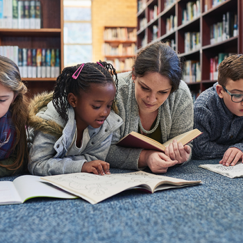 students reading on the floor with teacher