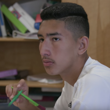 Teen male student listening in class