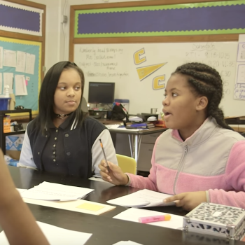 Two female students in a discussion in a classroom