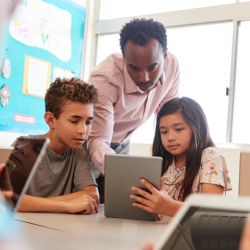 Teacher helping students in a PBL classroom