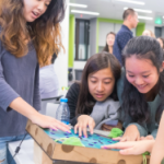 Students at a desk reviewing a project