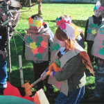 kids in paper armor and crowns outside doing a class project