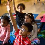 Students raising their hands to ask questions