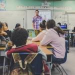 Teacher presenting to students sitting in groups