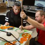 Teacher assisting student with engineering project